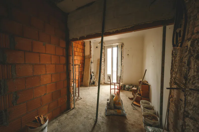A gutted room mid-renovation with construction debris ready for hauling in Bangor